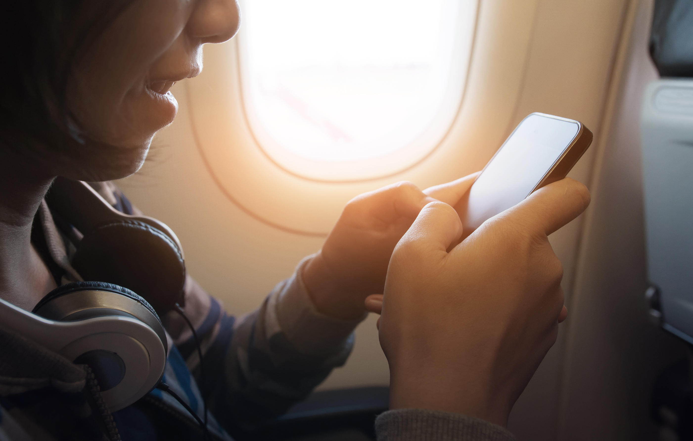 Woman-airplane-window-seat-phone.jpg?mtime=20180710124935#asset:102445