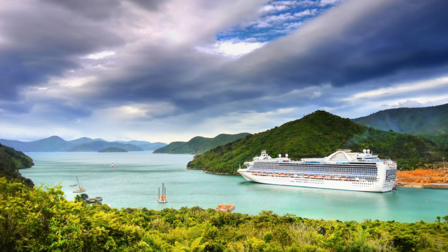 A cruise ship navigates a waterway in beautiful New Zealand mountains
