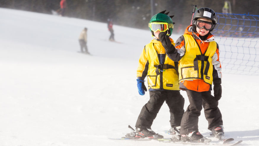Kids skiing with yellow jackets