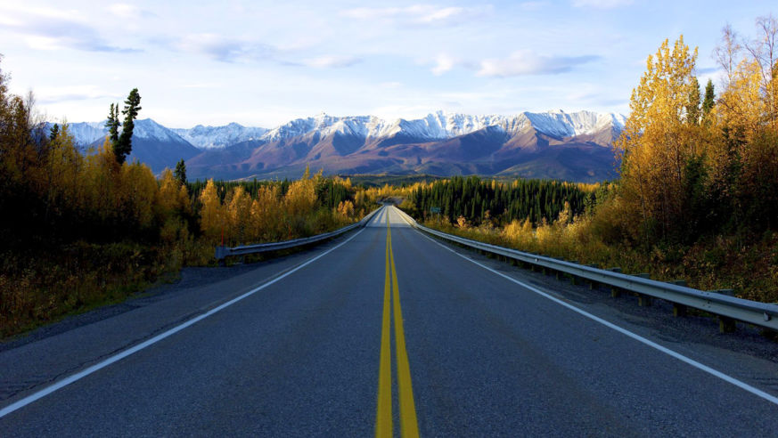 A view of an open highway with mountains in the distance.