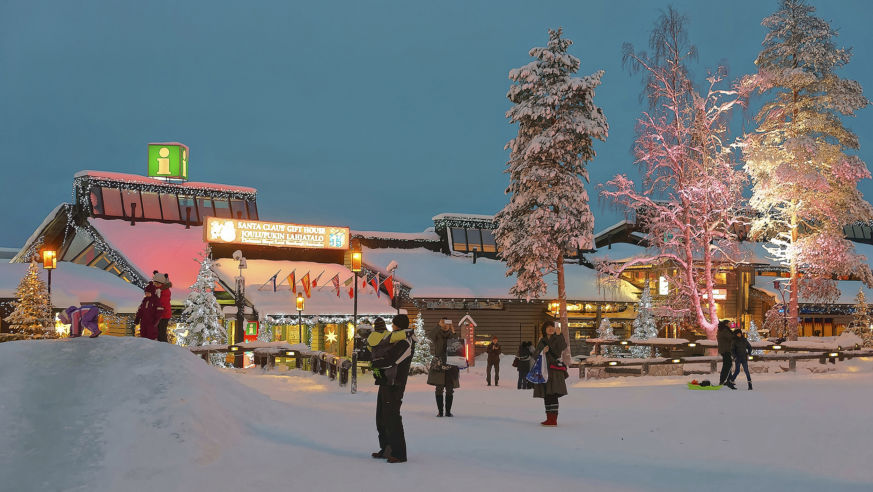 Families in the snow visiting Santa Claus Village in Finnish Lapland