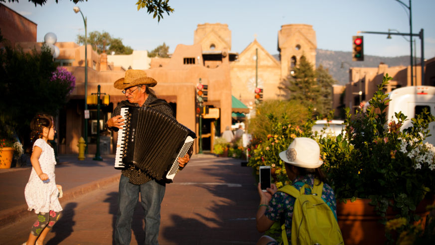 Man playing accordion while girl dances, mom takes photo