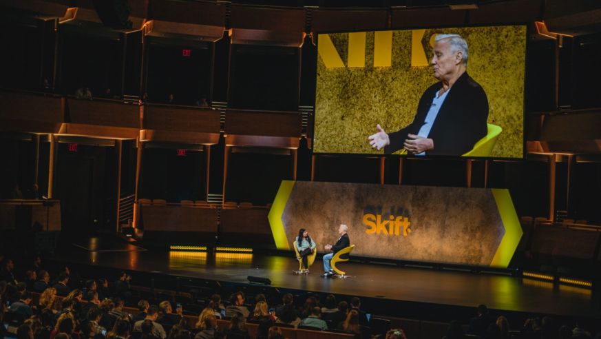 Interview on stage with screen in background