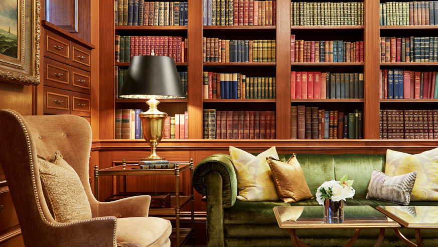 A view of a comfortable chair, sofa, and library shelves at the Jefferson DC Book Room.