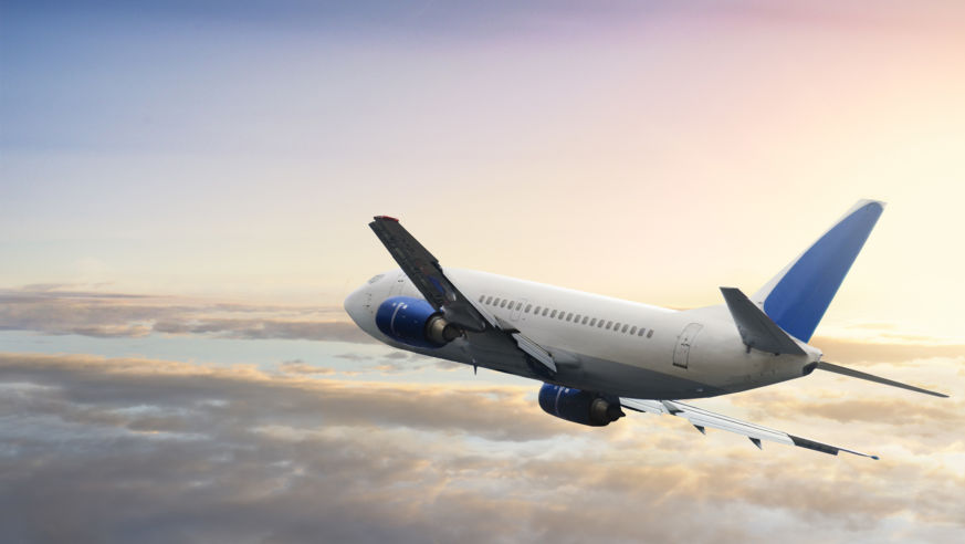 airplane flying at sunset