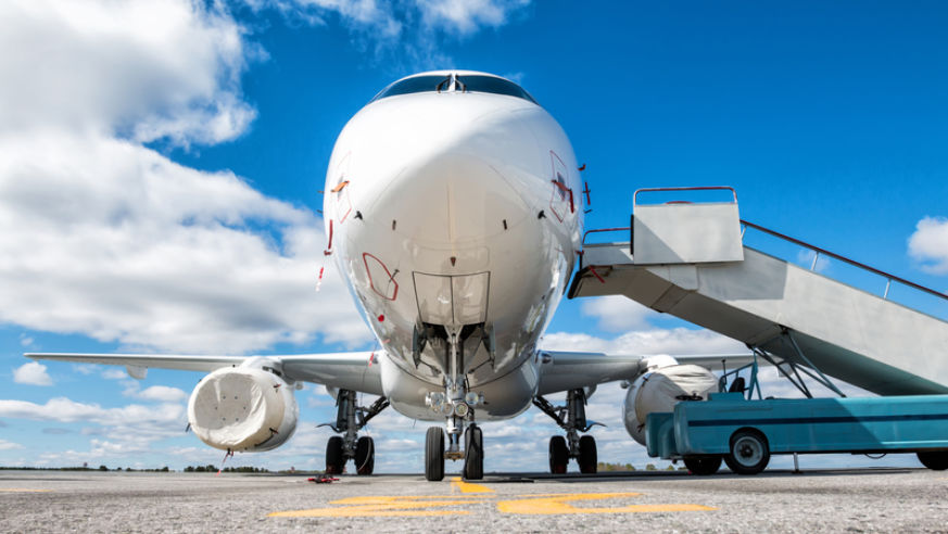 white airplane with boarding ramp