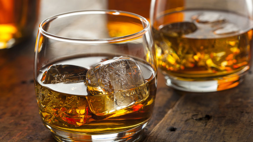 Two glasses filled with ice and bourbon