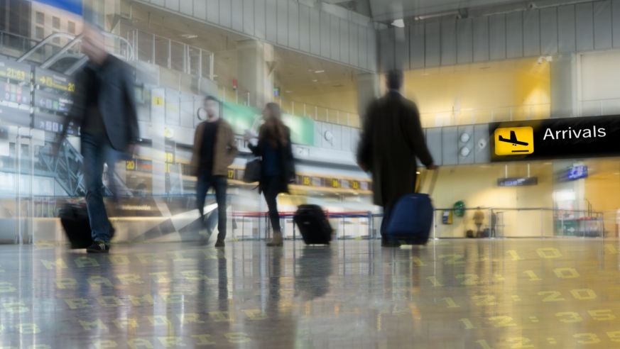 An image of airport passengers moving qjuickly through a terminal