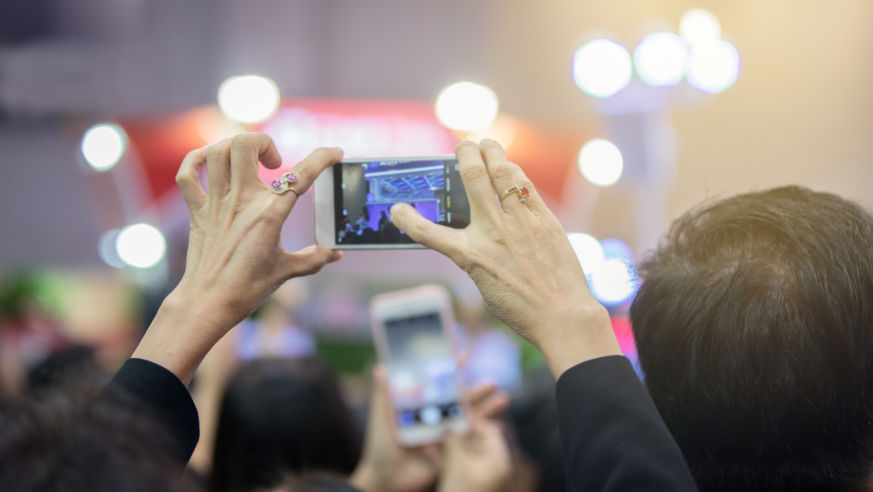 woman using camera phone at show