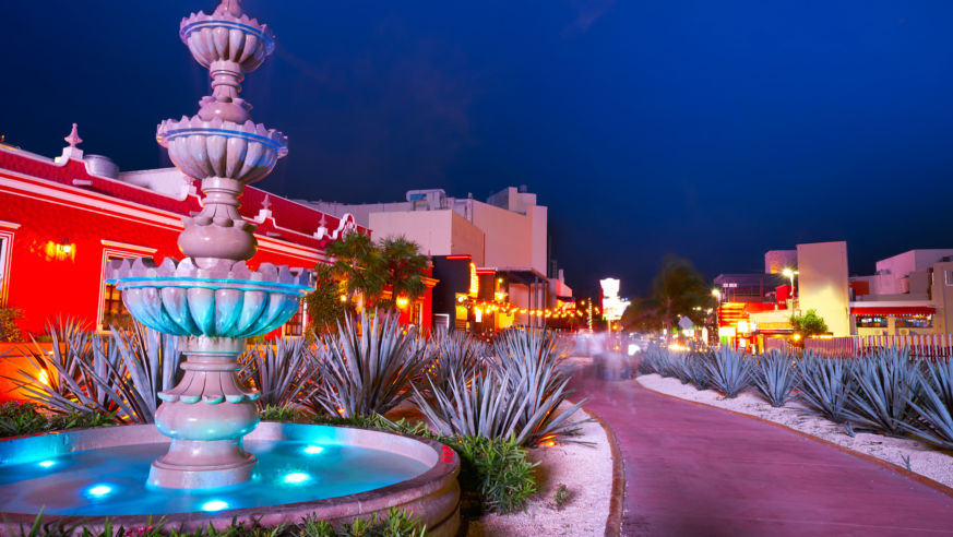 A view of a hotel fountain and colorful hotel in Cancun, Mexico.