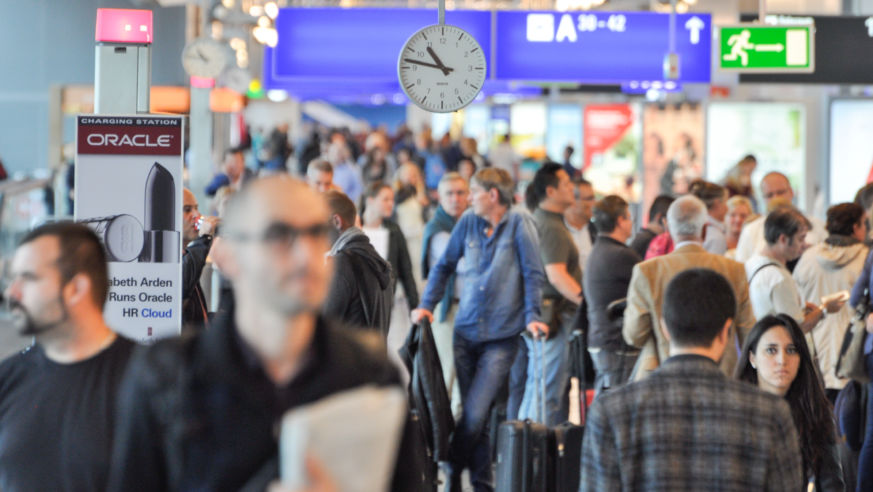 An airport corridor crowded with passengers.