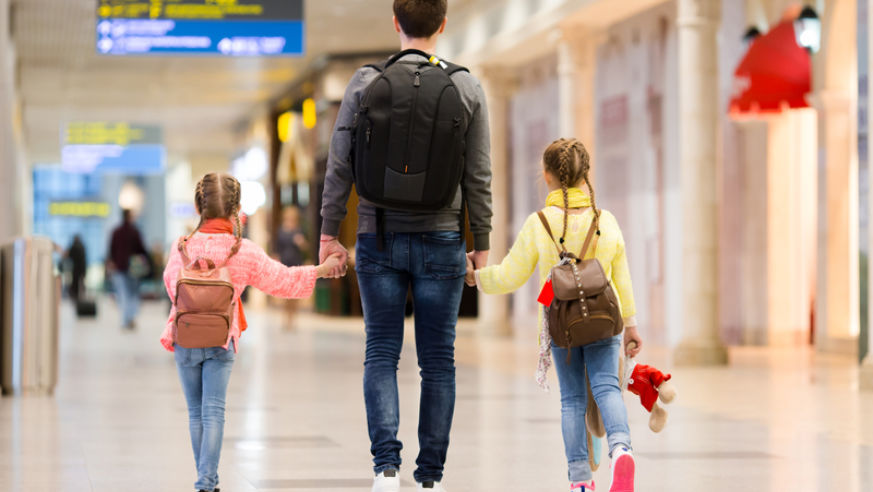 Father and two kids having fun at the airport.