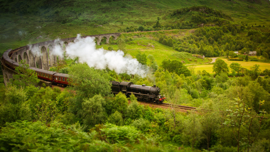 The Hogwarts Express train travels over a viaduct