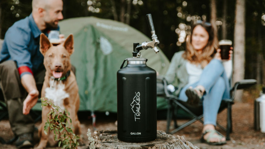 small keg at campsite people and dog