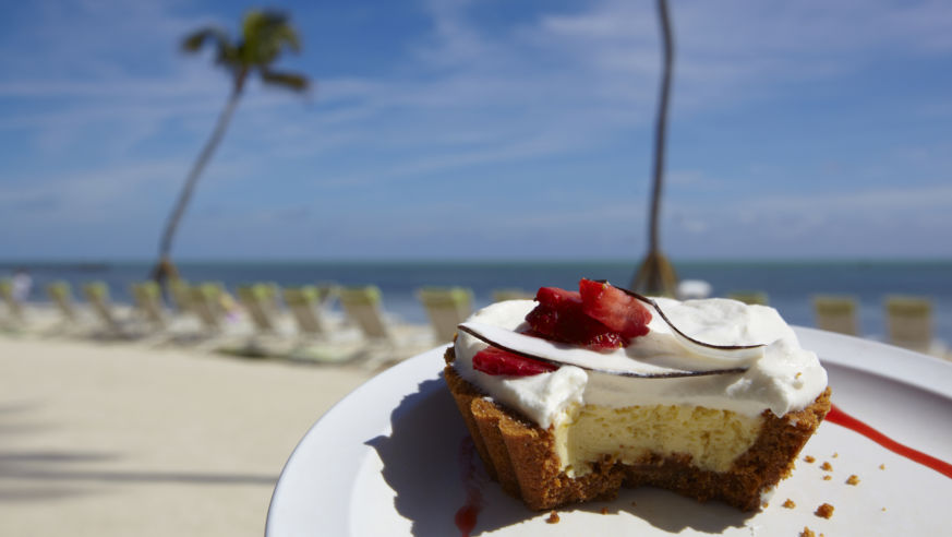 A slice of Key Lime pie on a tropical beach.