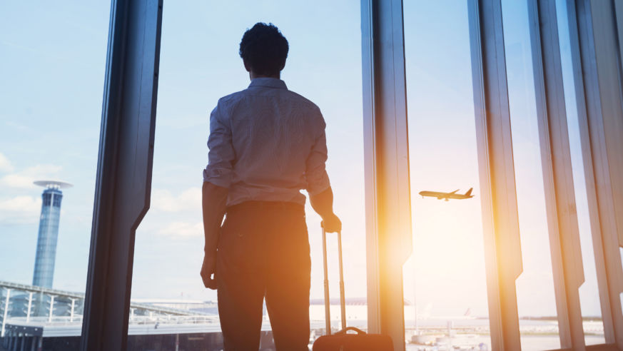 Man With Suitcase Looking Out Window