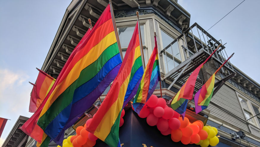 Rainbow pride flags decorate a Victorian-style building in San Francisco's Castro District
