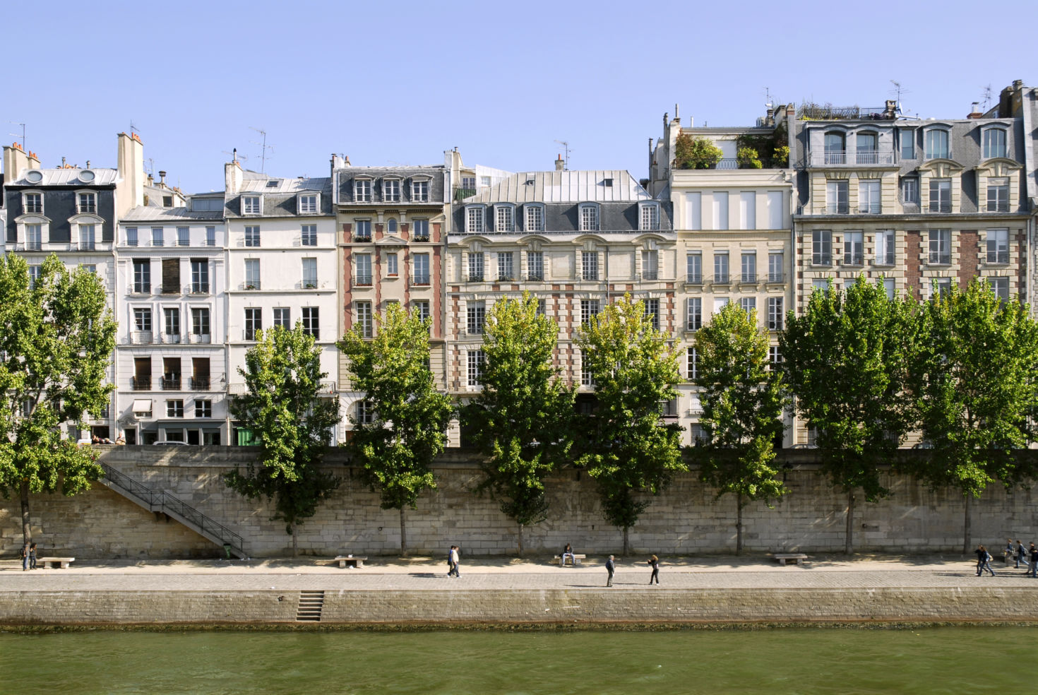 Famous quay of Seine in Paris with trees and buildings