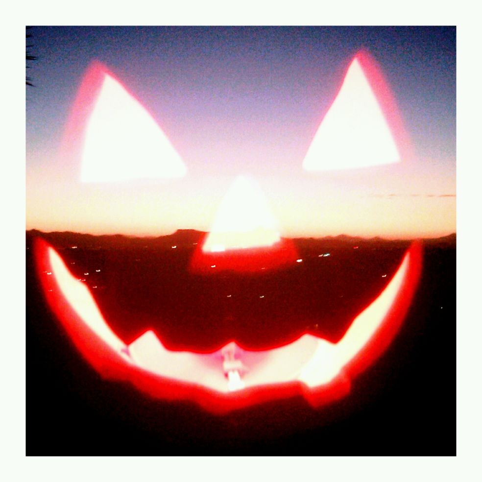 On Halloween night, I shot this juxtaposed photo of a lighted pumpkin with the setting sun on the desert horizon.