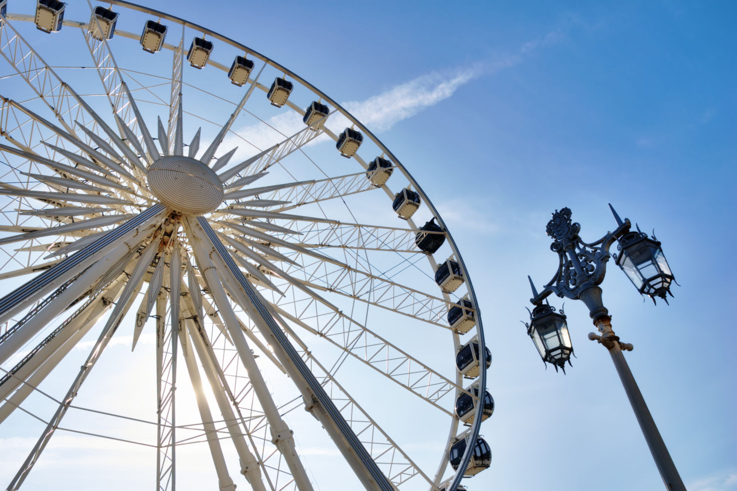 Large white ferris wheel ride over blue sky