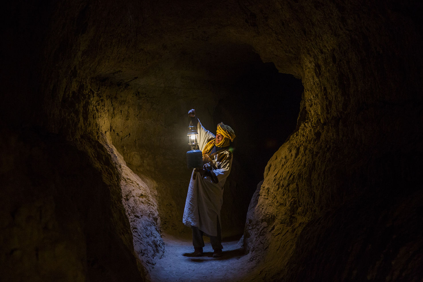 A Berber man stands in a tunnel that once carried water to irrigate farmland in the desert