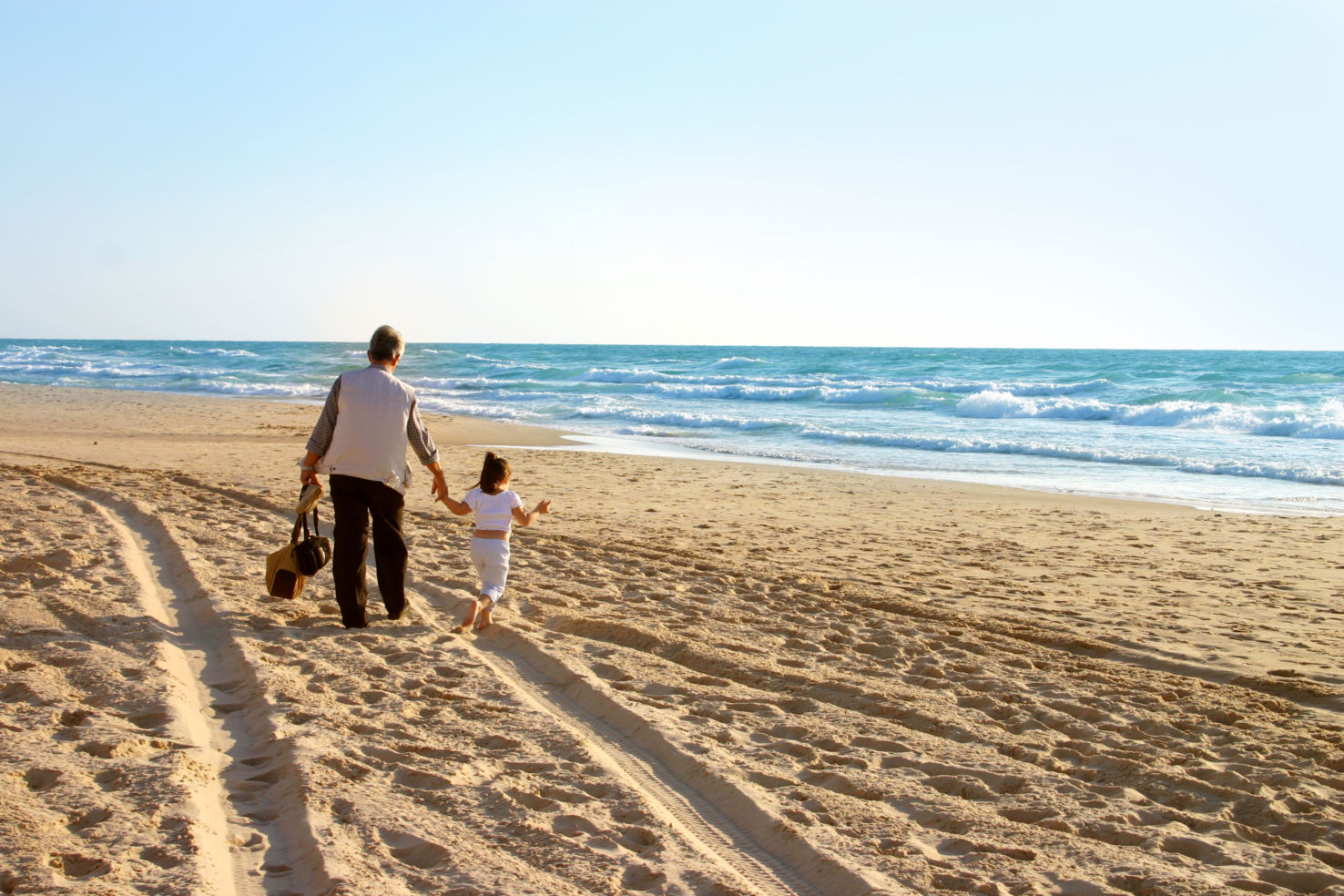Little girl and grandfather on beach