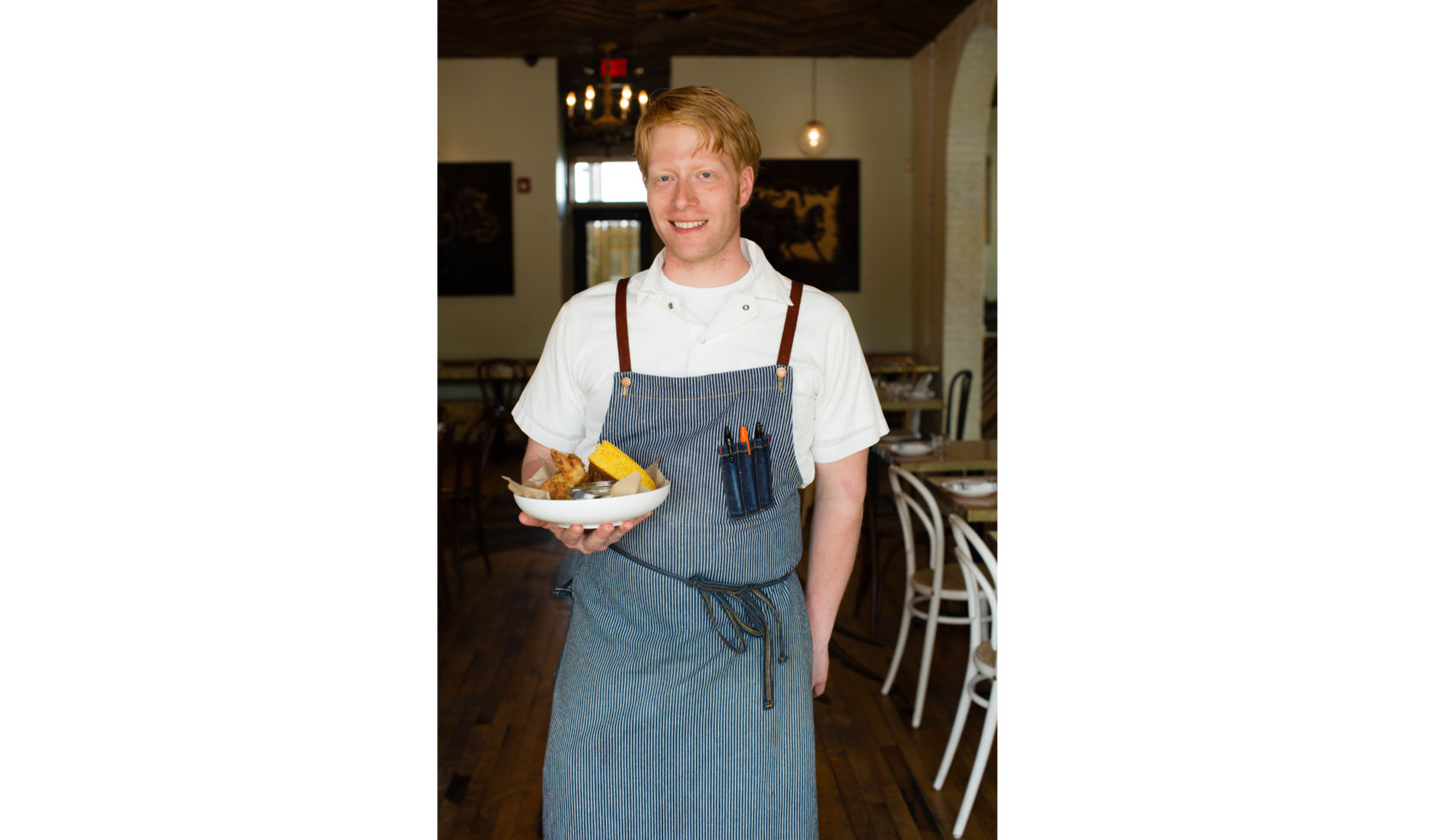 Sous chef Reid Shipman holds the restaurant’s signature pickled brine fried chicken with pepper gravy.