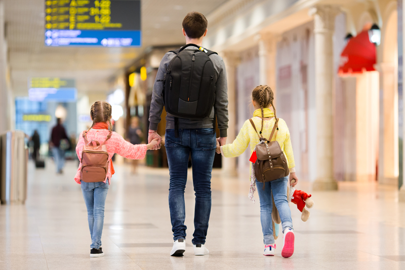Father and two kids having fun at the airport.